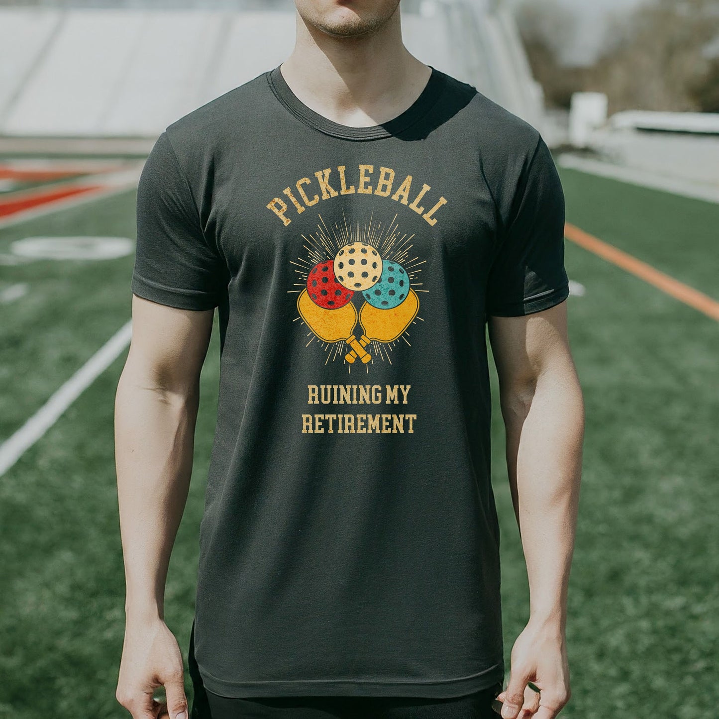 a man wearing a pickleball shirt standing on a field