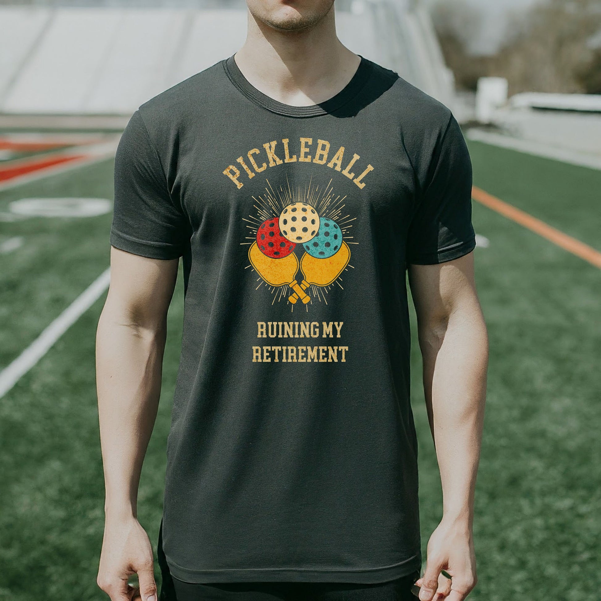 a man wearing a pickleball shirt standing on a field