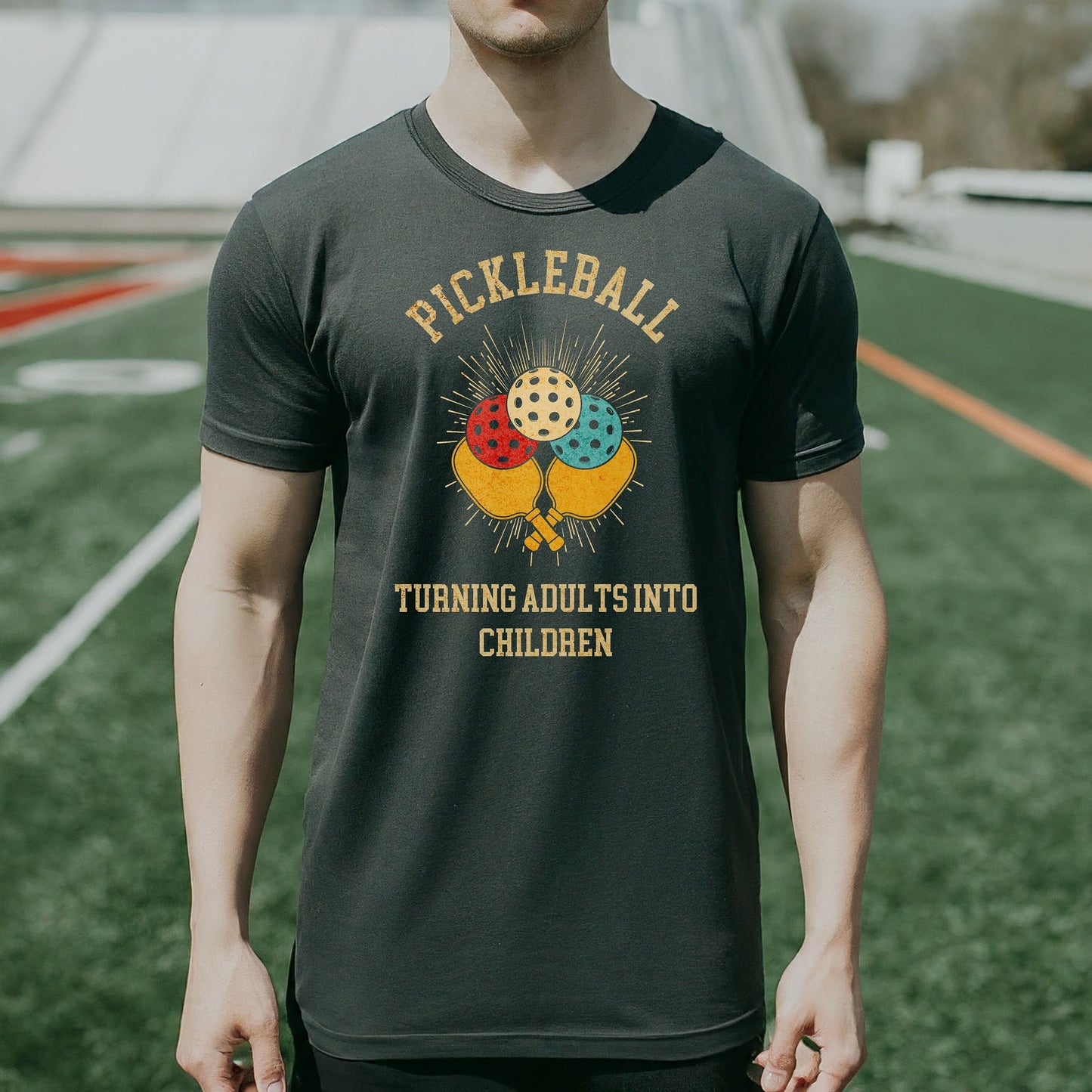 a man standing on a field wearing a t - shirt