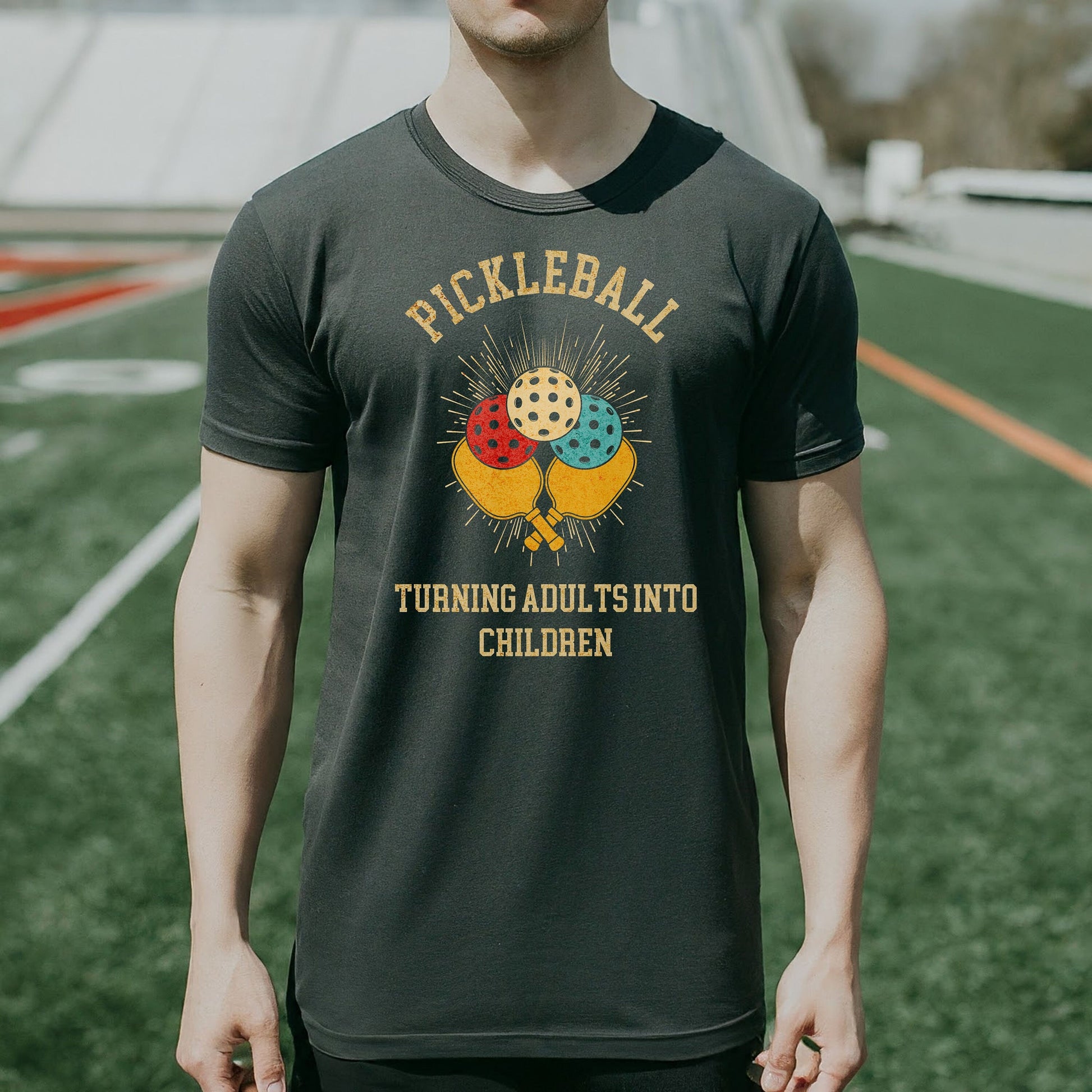 a man standing on a field wearing a t - shirt
