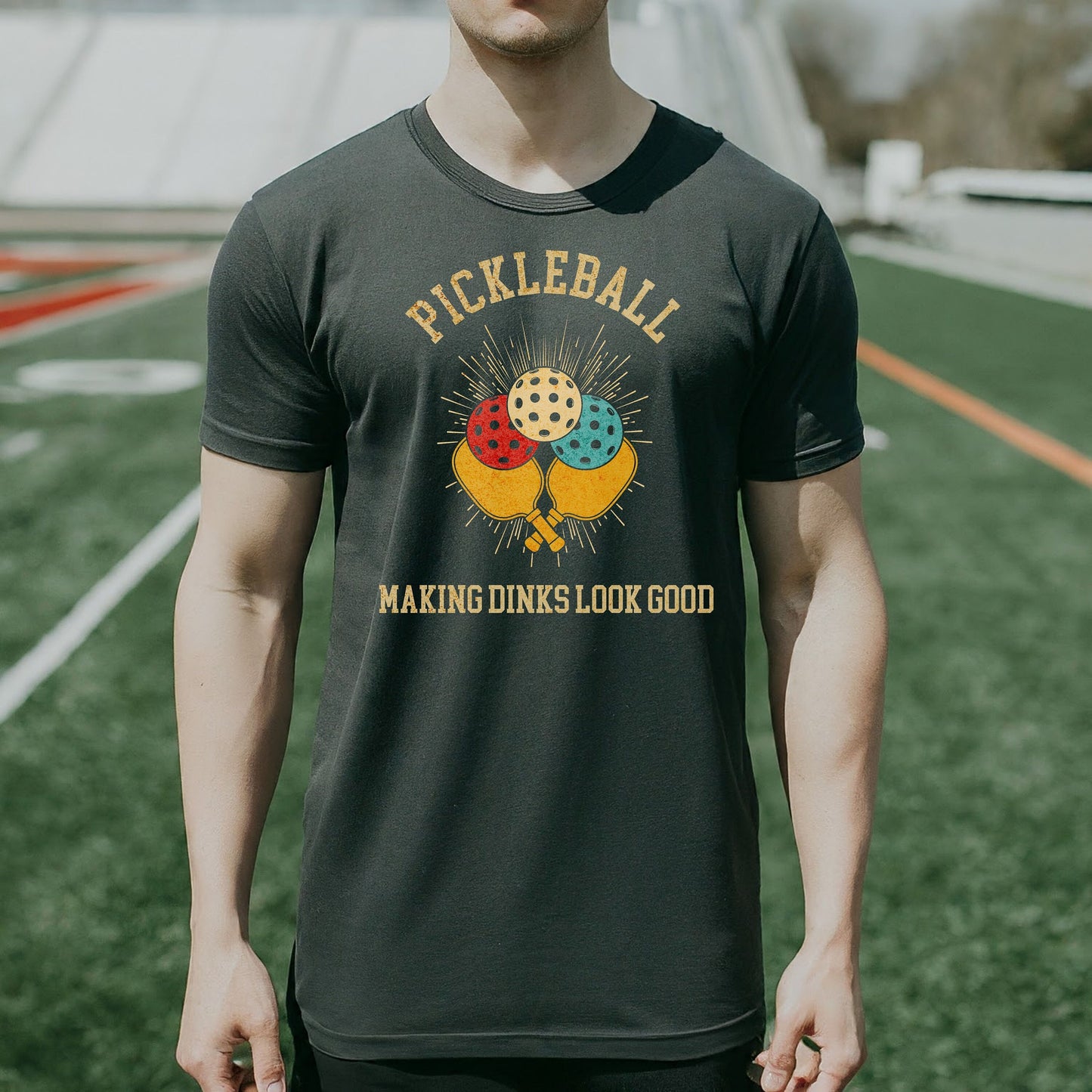 a man wearing a pickleball shirt standing on a field