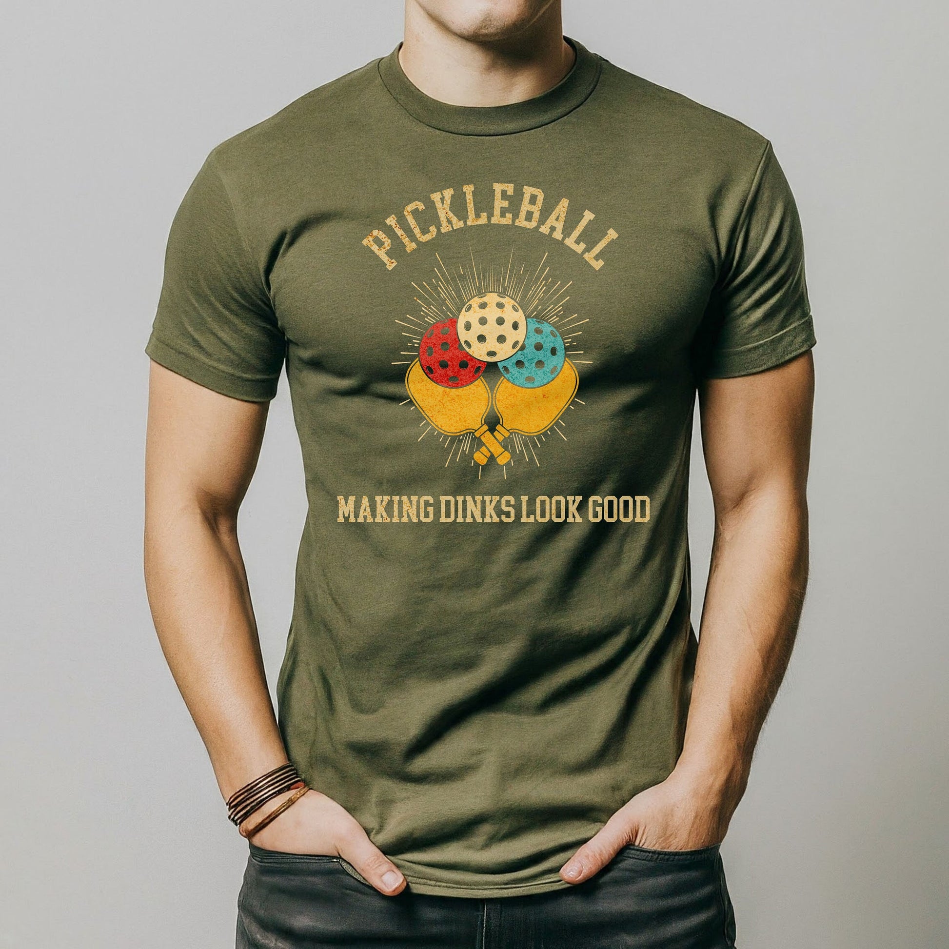 a man wearing a pickleball t - shirt with his hands in his pockets