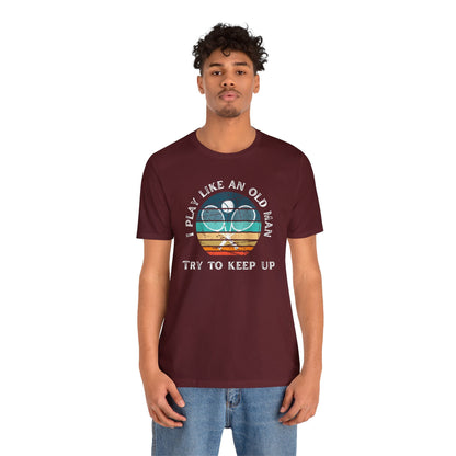 a man wearing a t - shirt that says play like an old man try to
