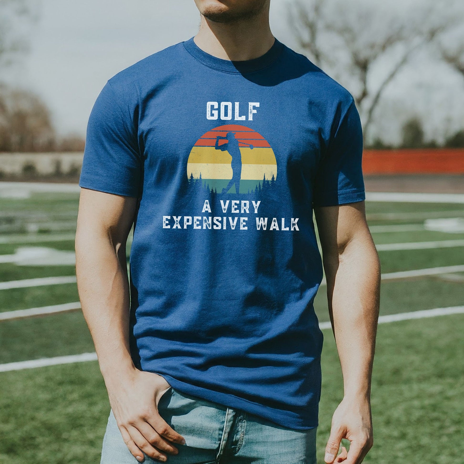 a man standing on a field wearing a blue golf t - shirt