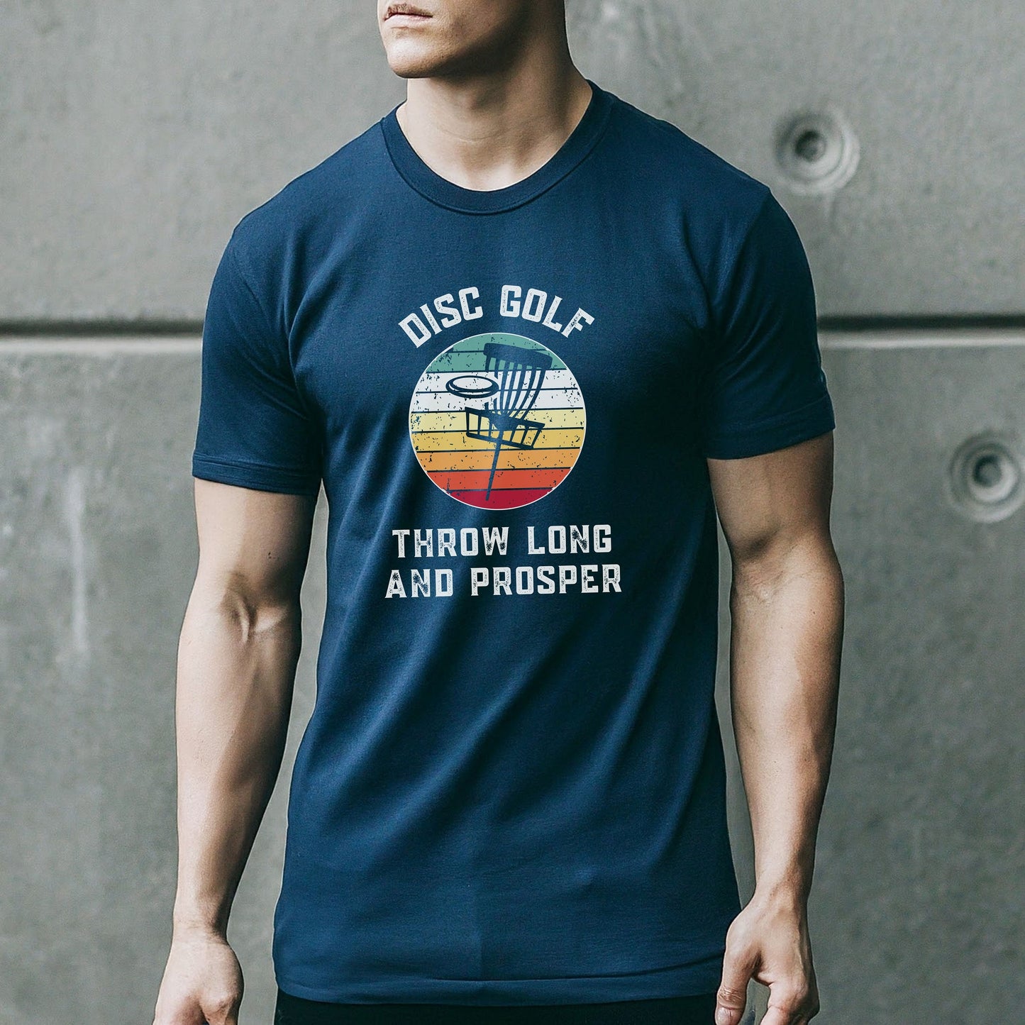 a man wearing a disc golf t - shirt standing in front of a wall