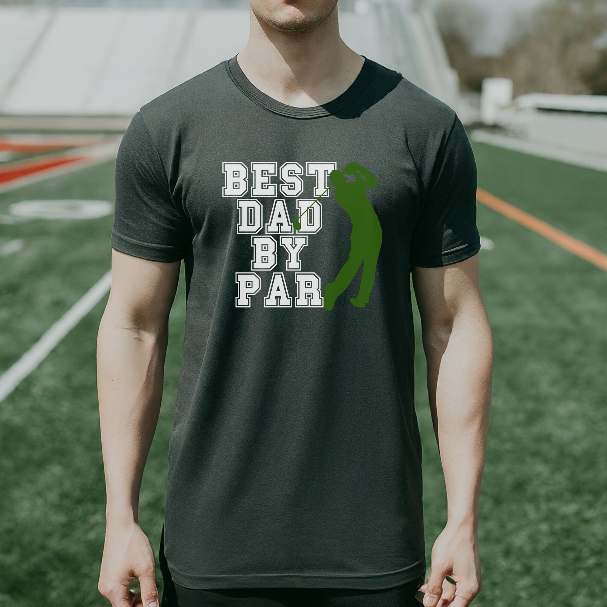 a man standing on a field wearing a t - shirt that says best dad by
