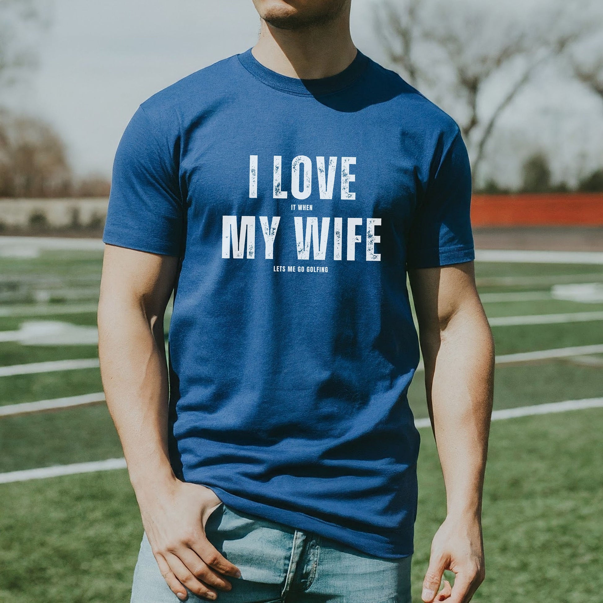 a man in a blue shirt standing on a field