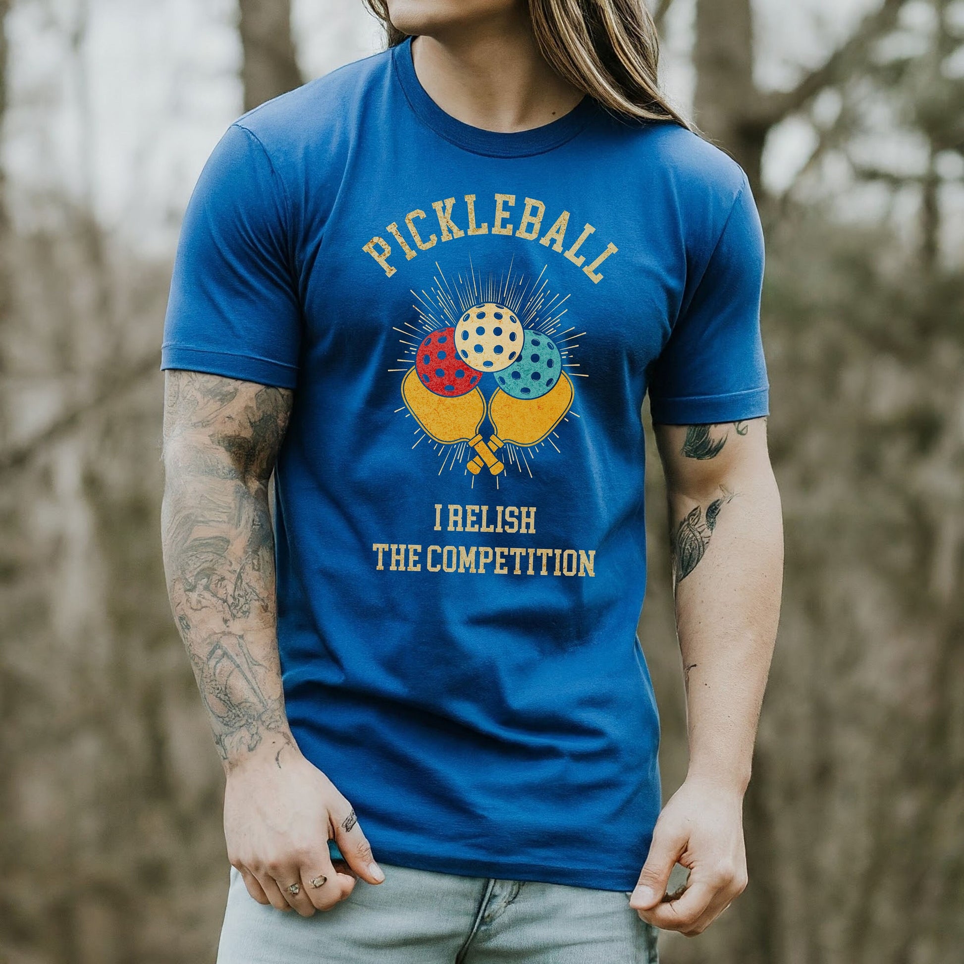 a man wearing a pickleball t - shirt in the woods