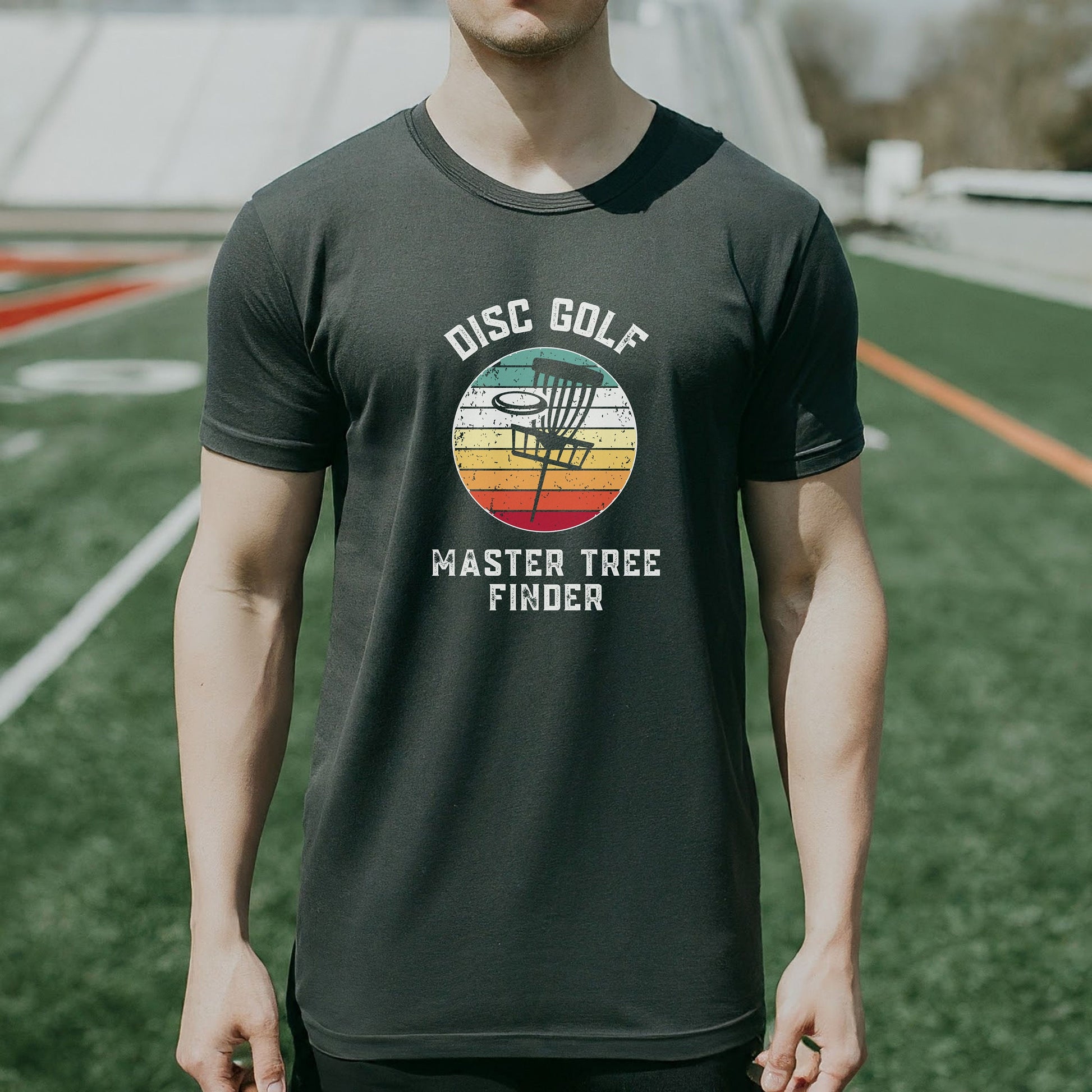 a man standing on a field wearing a disc golf master t - shirt