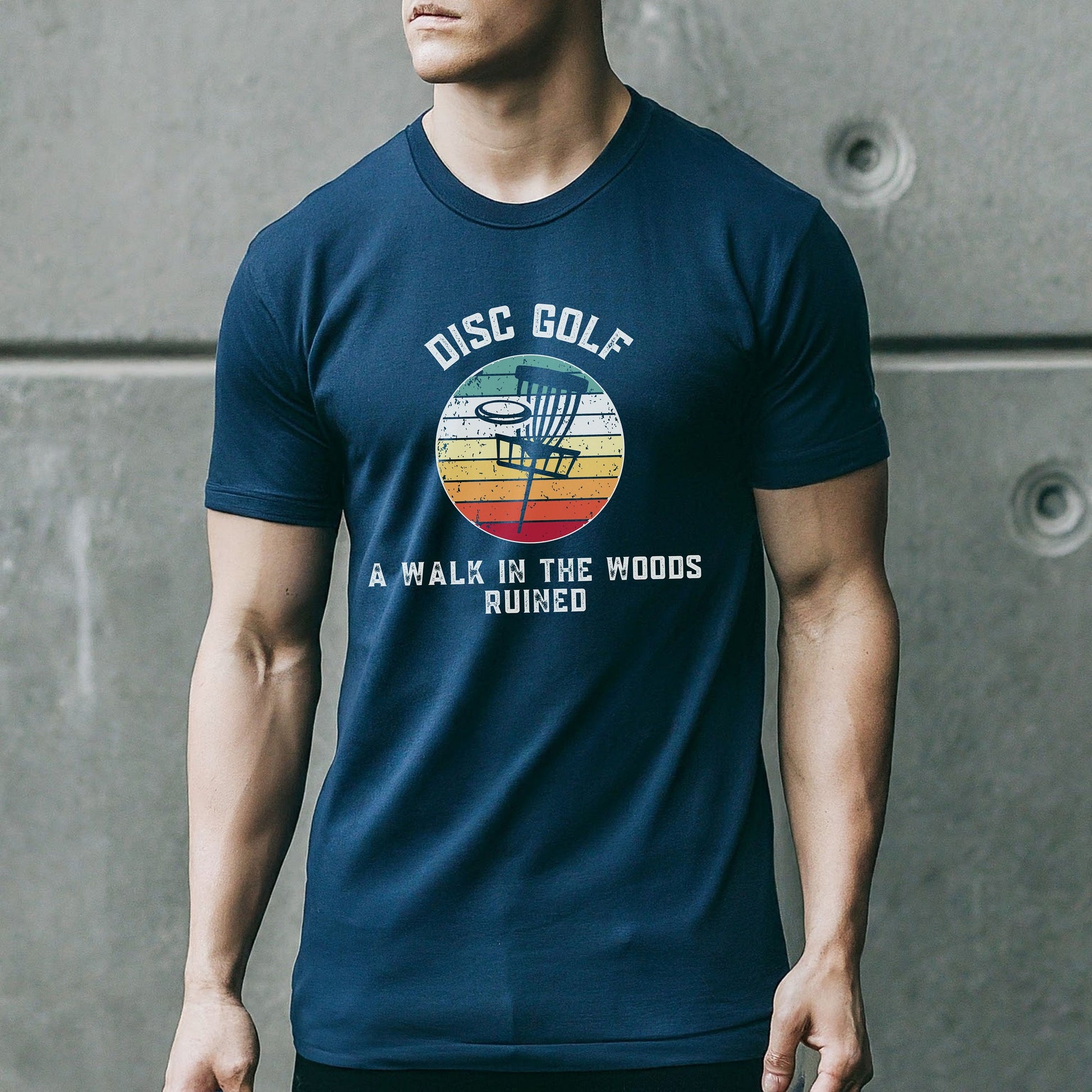 a man wearing a disc golf t - shirt standing in front of a wall