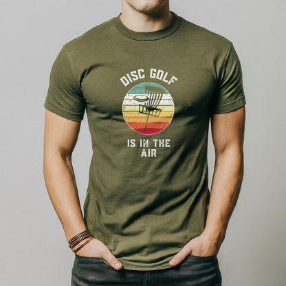 a man wearing a disc golf is in the air t - shirt