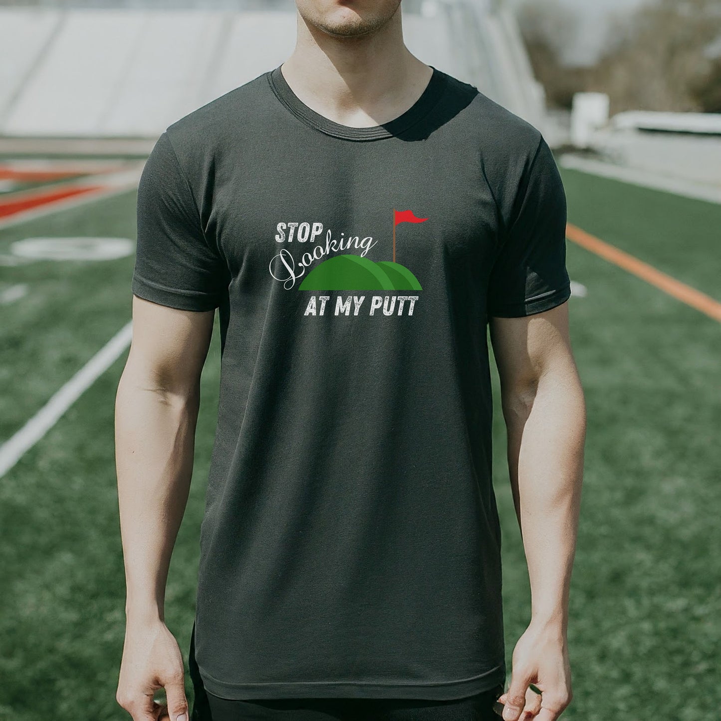 a man standing on top of a field wearing a black shirt
