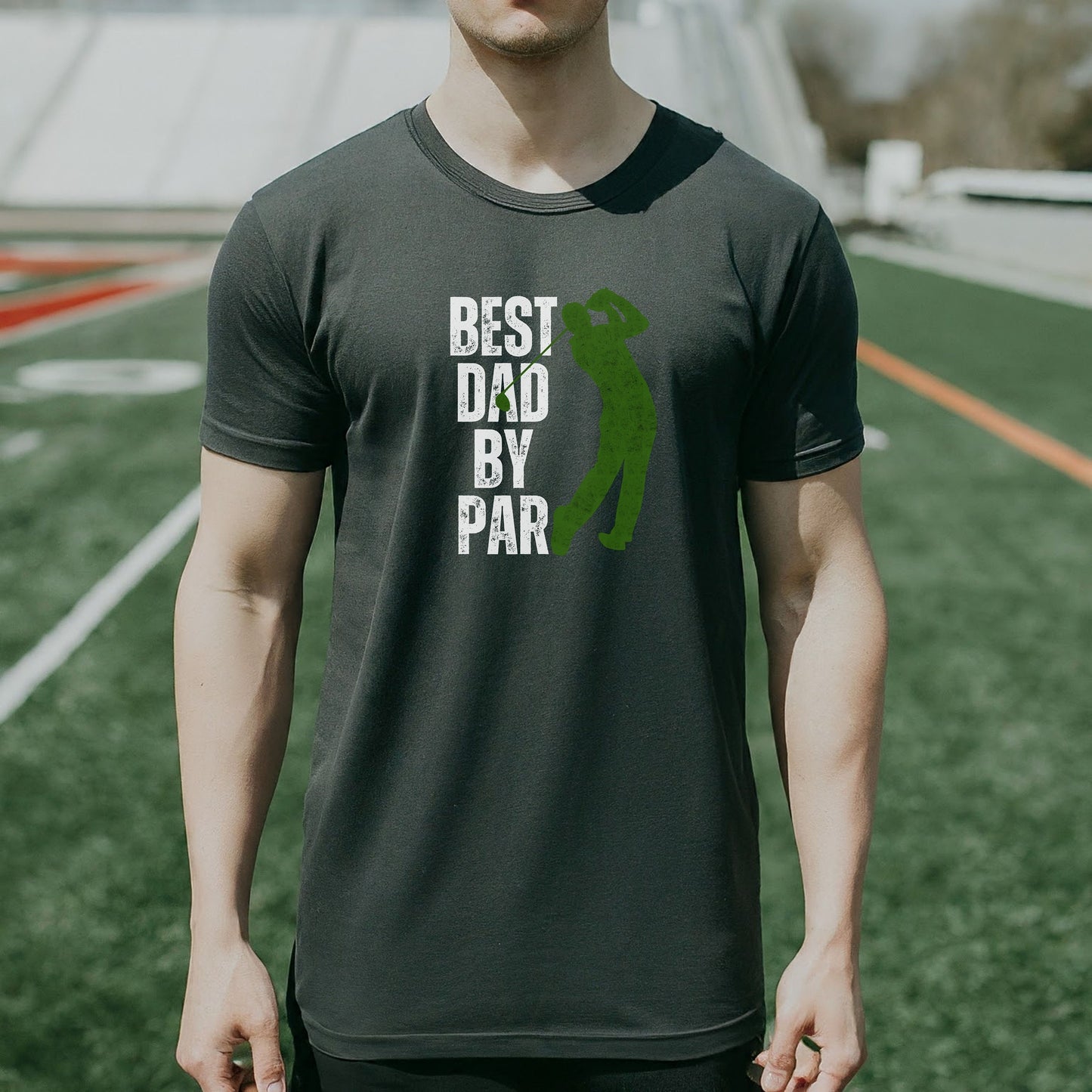 a man standing on a field wearing a shirt that says best dad by par