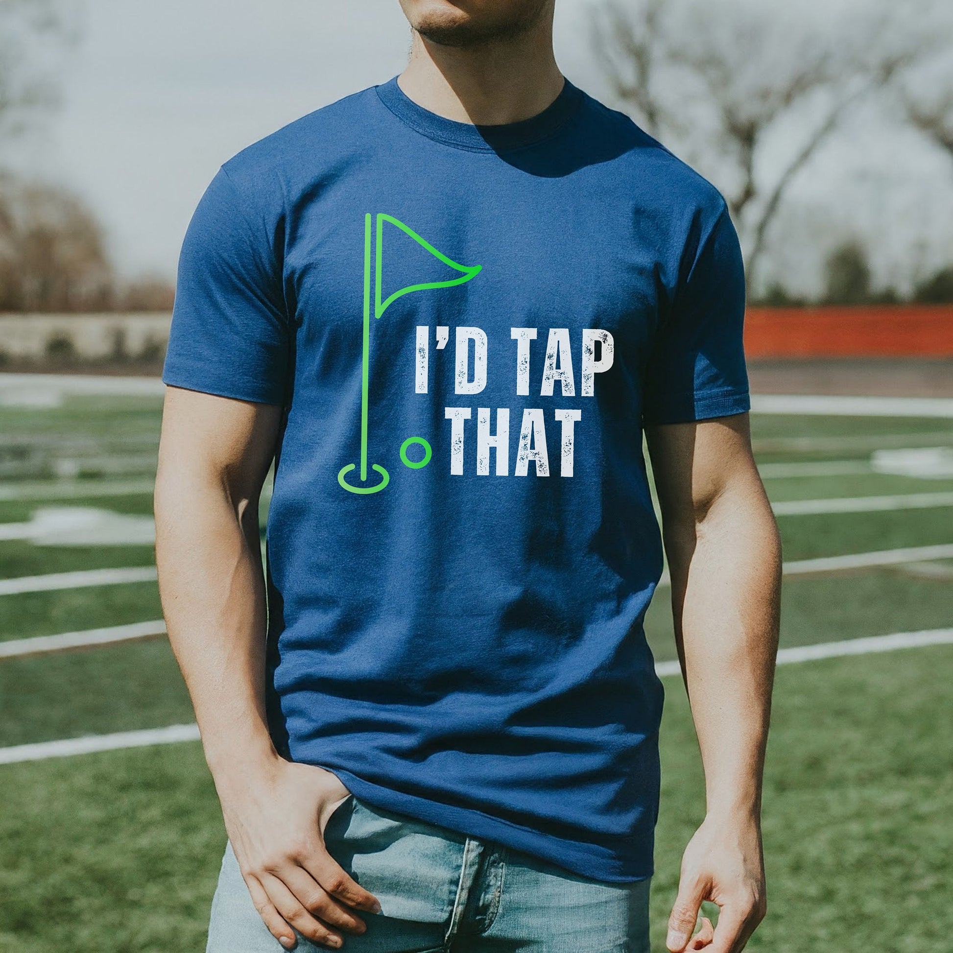 a man standing on a field wearing a blue tee shirt with the words i '