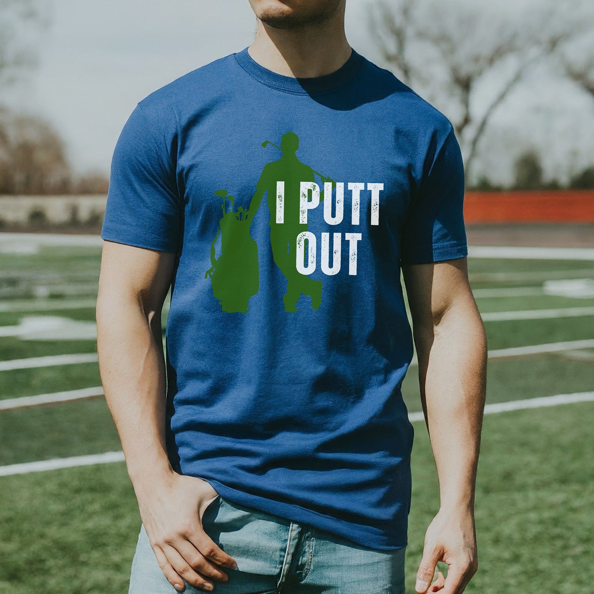 a man standing on a field wearing a blue shirt
