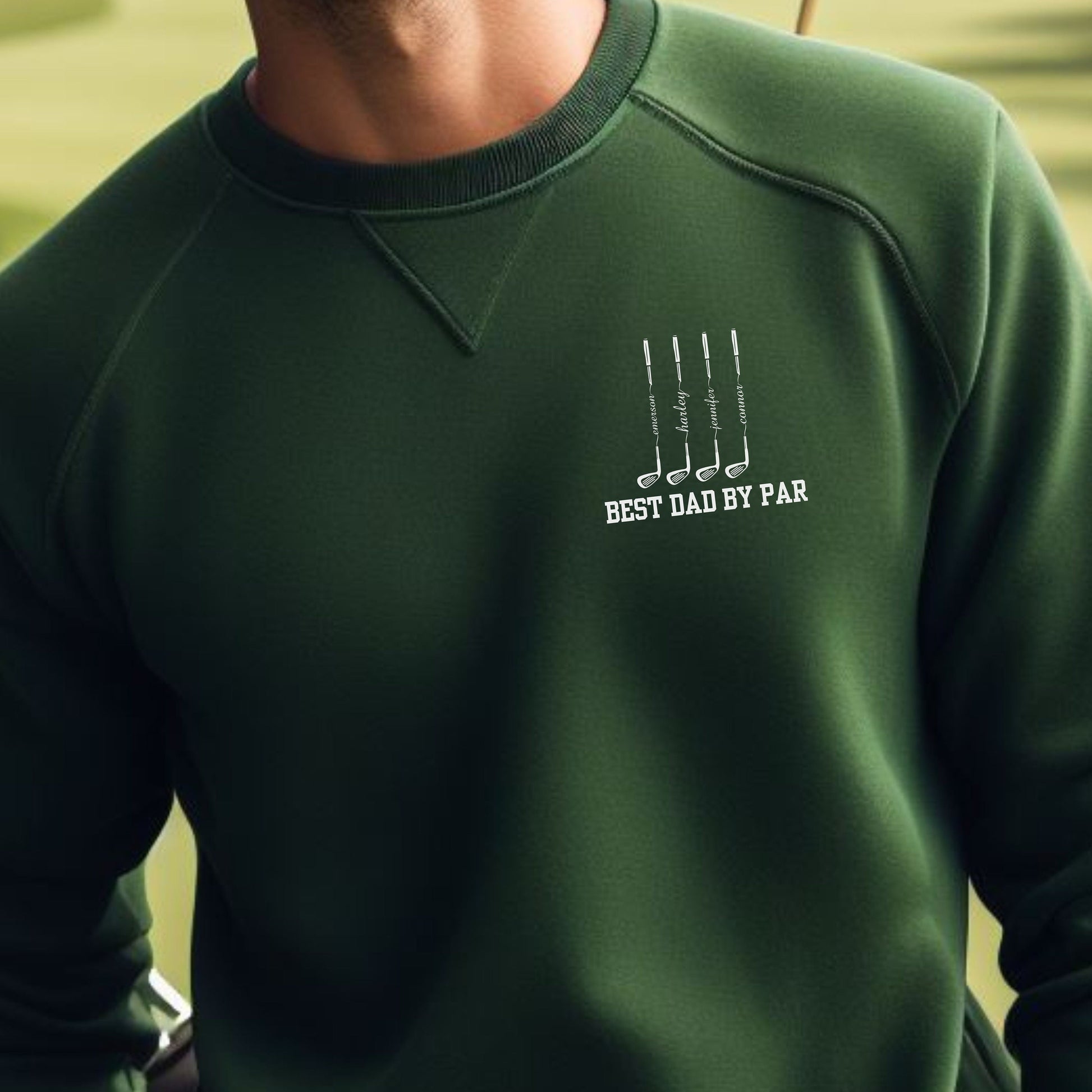 a man wearing a green sweatshirt with the words best dad by far on it